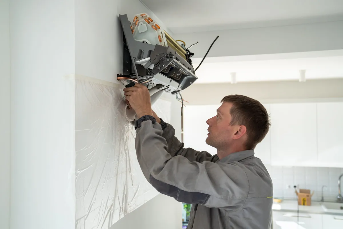 Technician installing a wall-mounted ductless mini-split indoor unit — illustrative stock photo, not an actual St. George job site